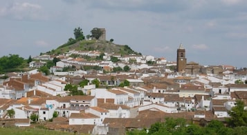 Un pueblo con muchas construcciones blancas y una imponente torre de iglesia en una colina.