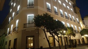 Een hotel met meerdere verdiepingen, verlichte ramen en balkons.