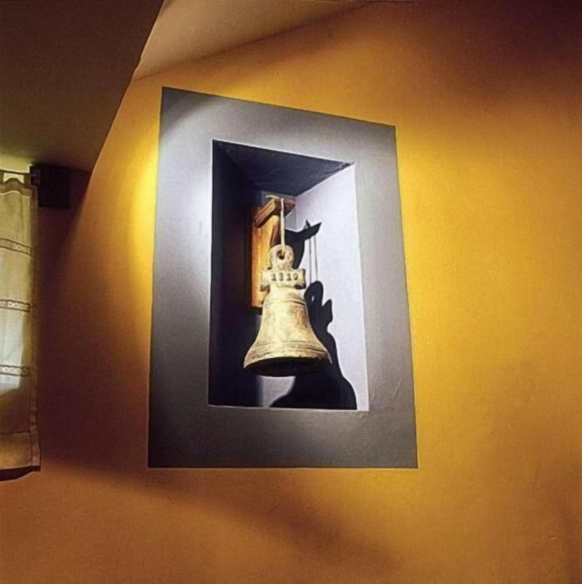 Una campana enmarco con una sombra en la pared.