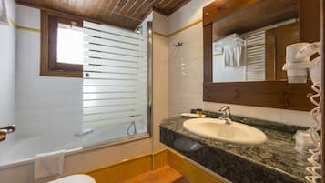 A bathroom with a bathtub, sink, and mirror.
