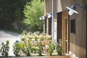 A wooden building with a door and a row of potted plants in front. - Centro De Ecoturismo Tierra Del Agua (Caso)