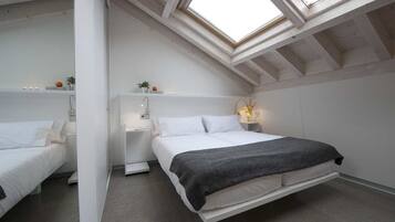A modern bedroom with a skylight, a bed, bedside tables, and a nightstand.