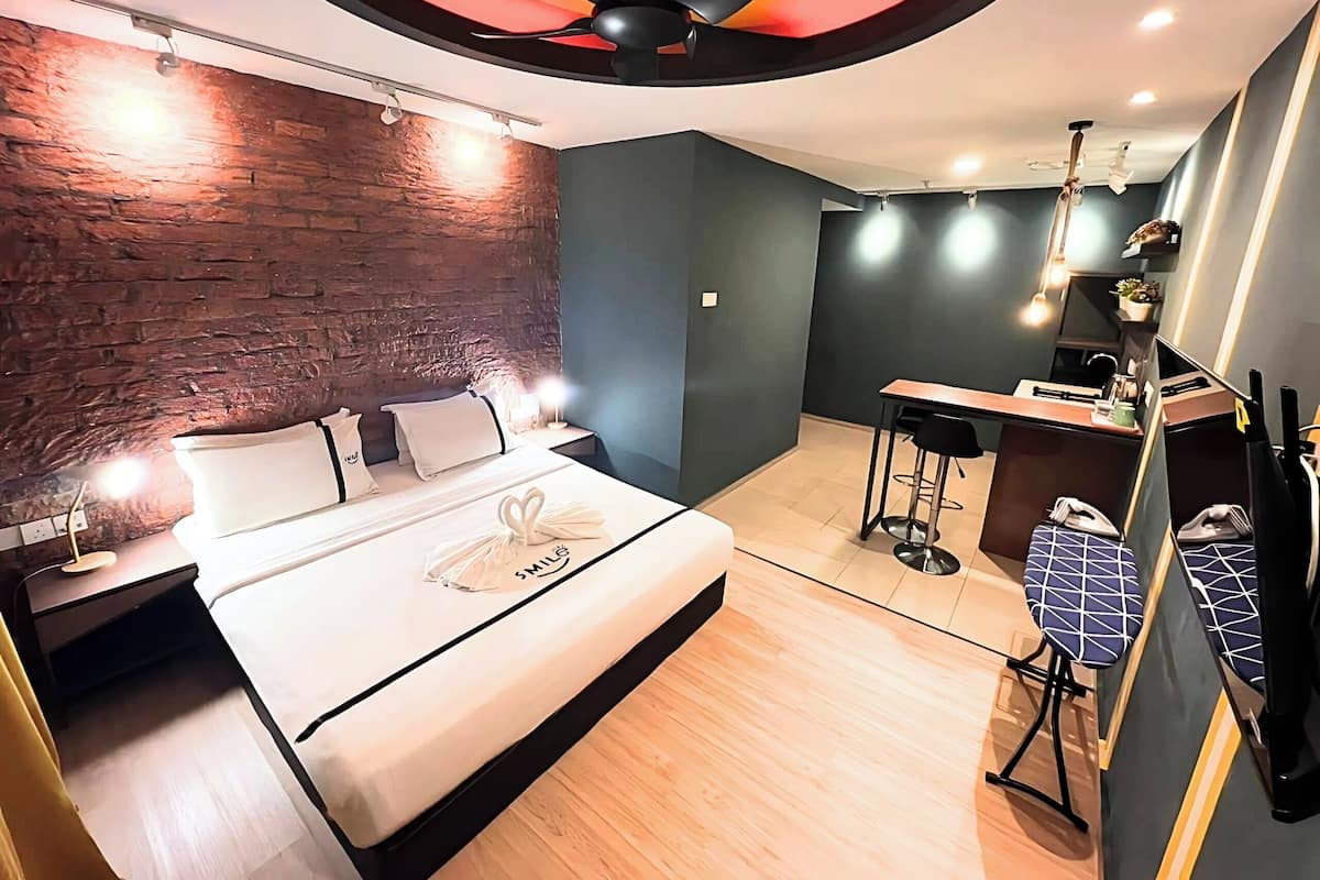 A modern hotel room with a bed, a desk, and a chair.