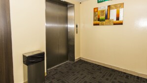 An elevator with a number 2 sign, a trash bin, and a wall with a 'KELUAR' sign. - Smile Hotel USJ (Subang Jaya)