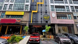 A multi-story hotel with a modern facade, large windows, and a prominent yellow and black sign indicating a hotel named 'SMILE'. - Smile Hotel USJ (Subang Jaya)