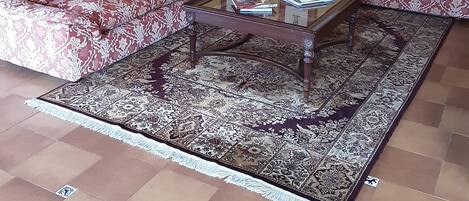 A living room with a patterned sofa set, a coffee table, and a rug.