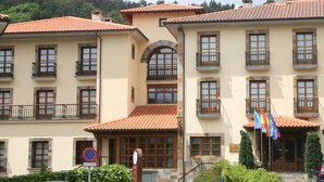 Ein mehrstöckiges Hotel im traditionellen Baustil, mit Balkonen und einem Ziegeldach.