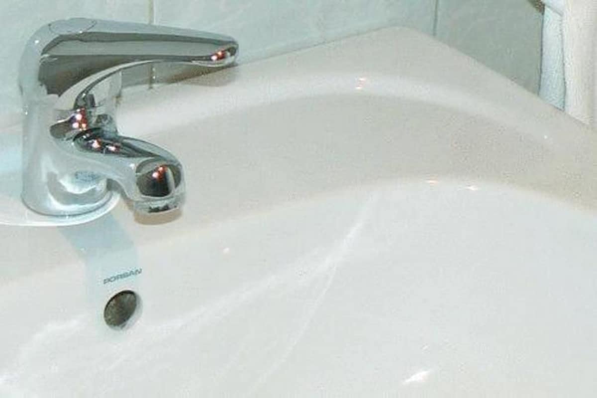 Un lavabo de salle de bain avec un robinet chromé et un drain visible.