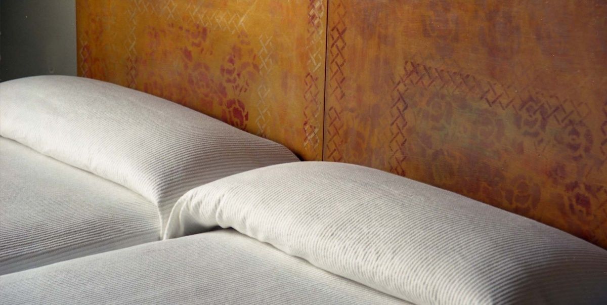 A bed with a headboard featuring a geometric pattern.