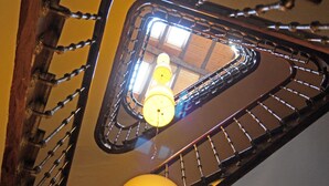 A light fixture with a chain design, a visible bulb, and a reflective surface. - La Colmena (Valdes)