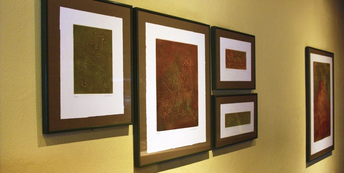 A wall with four framed artworks.
