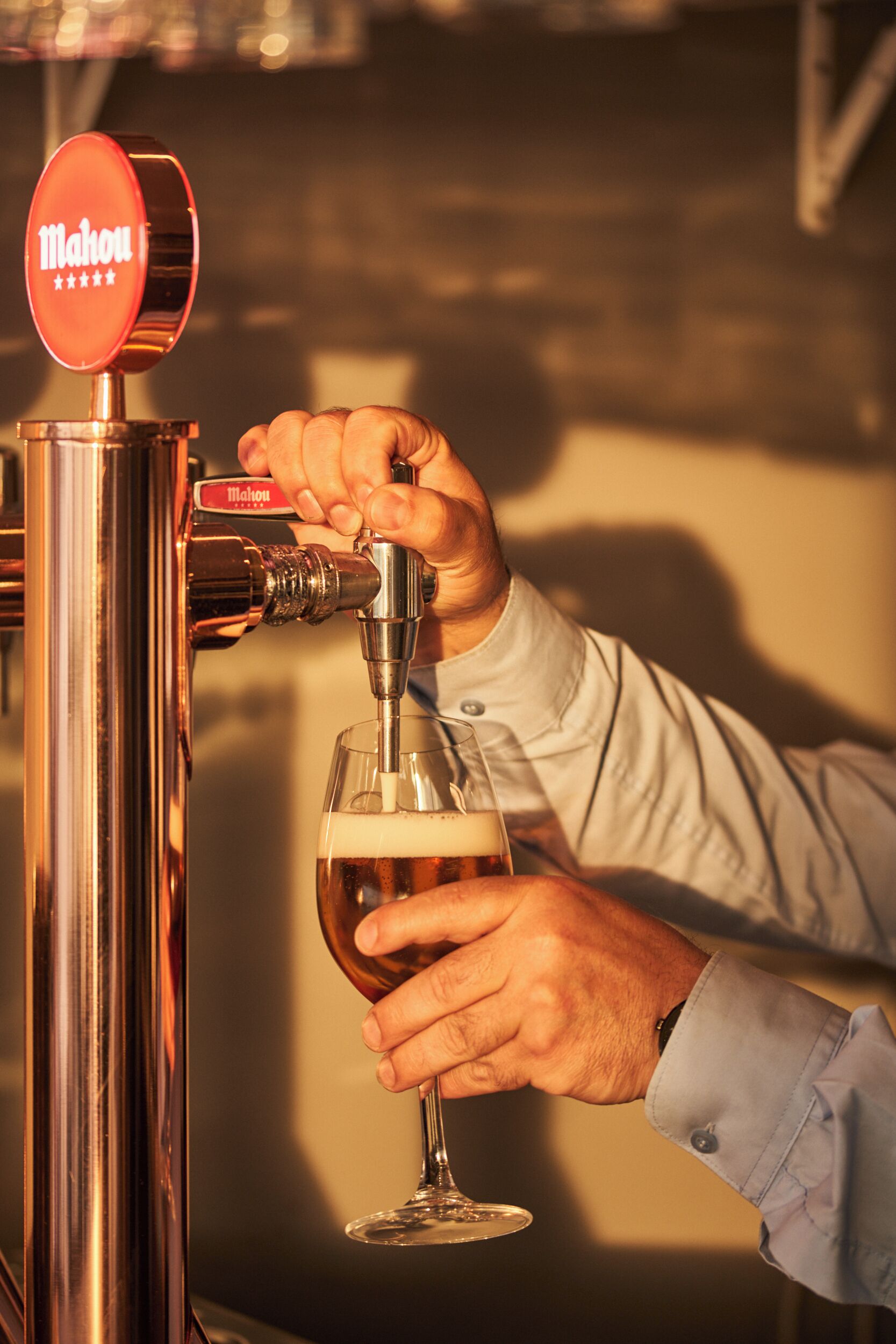 A person pouring beer from a tap into a glass.