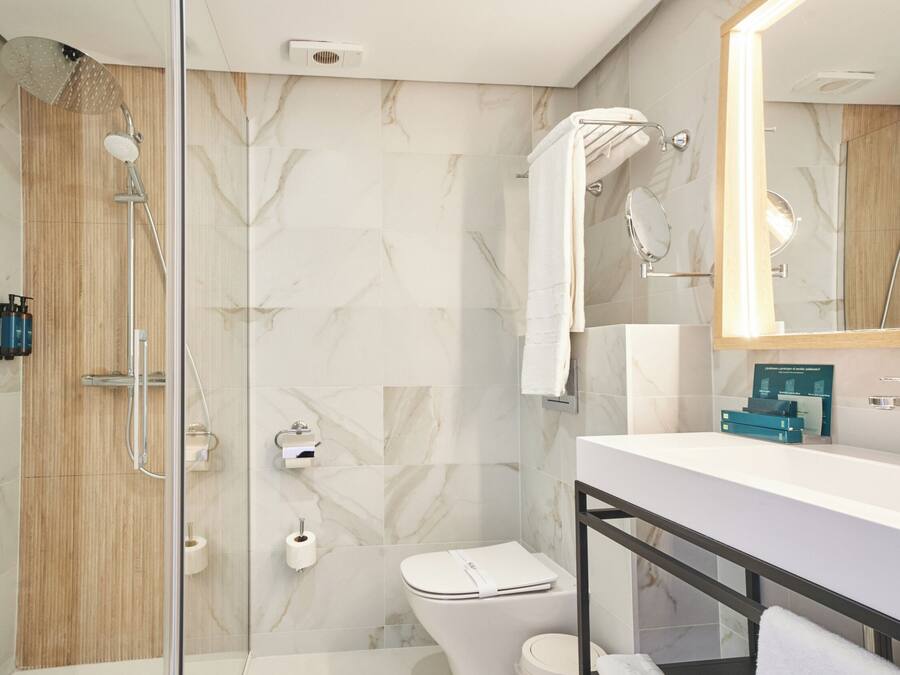 Une salle de bain moderne équipée d’une douche, de toilettes et d’un lavabo.