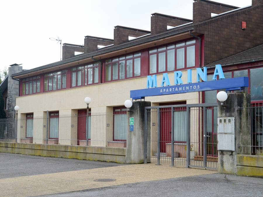 A building with a sign reading "MARINA APARTMENTOS" indicating it is an apartment complex.