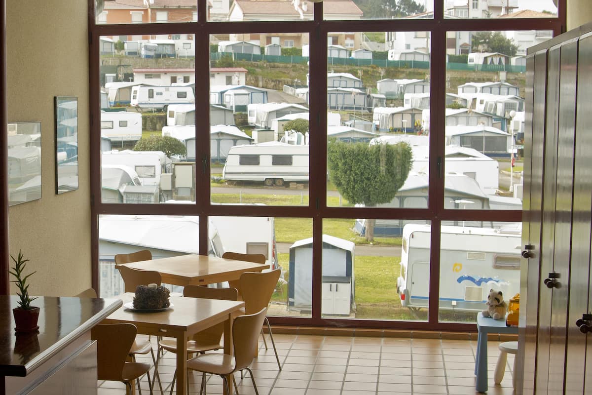 A room with a large window overlooking a caravan park.