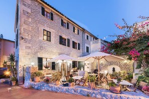A stone building with outdoor seating and potted plants. - Ca Mado Paula (Banyalbufar)