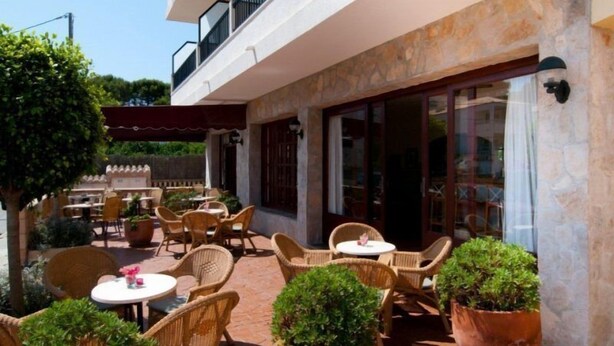 An outdoor patio with wicker furniture and potted plants. - Marbel (Cala Ratjada)