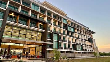 Um hotel moderno com vários andares, com varandas e área de estar externa coberta.