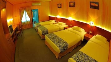 Una habitación de hotel con cuatro camas, un escritorio y un televisor.