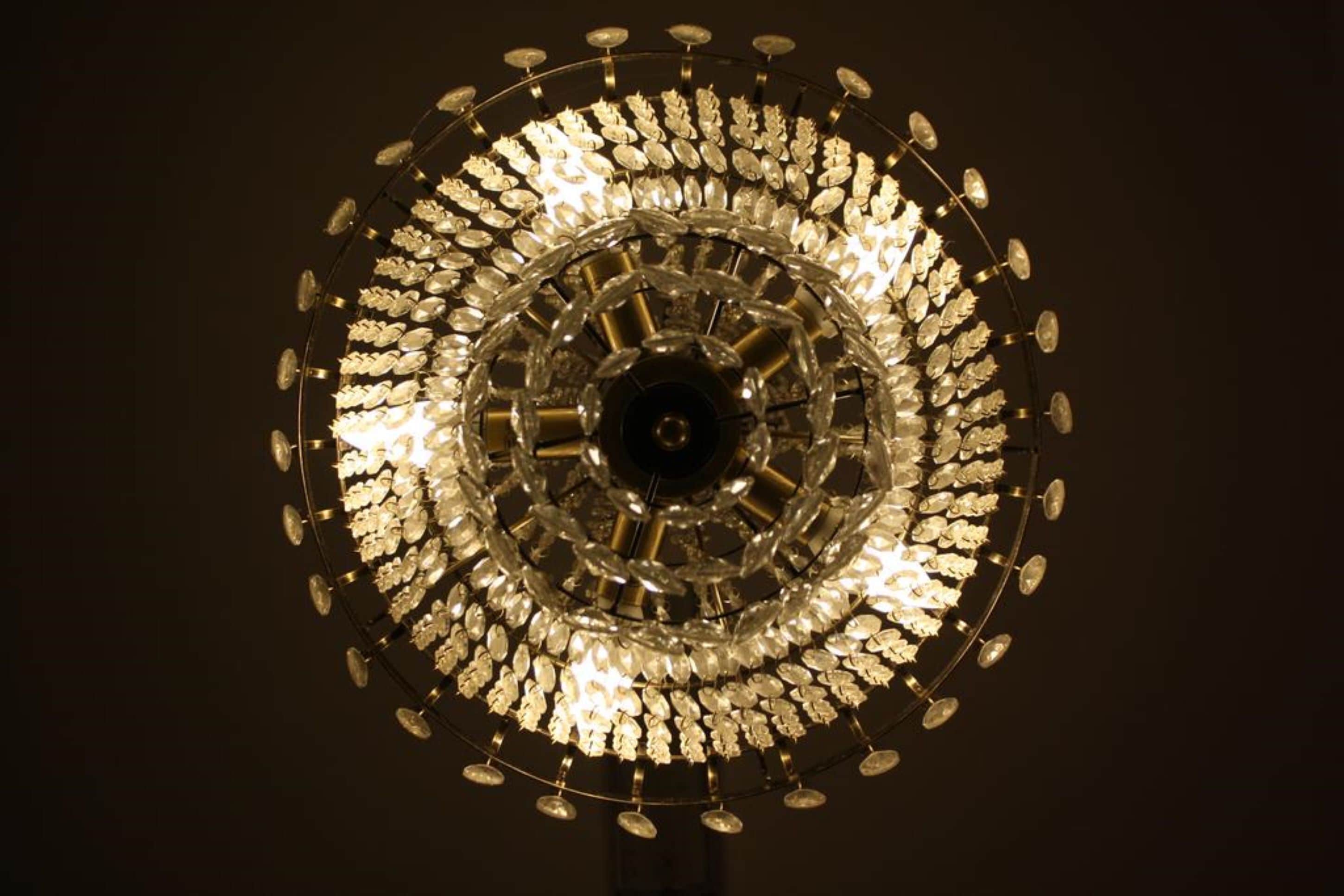 A circular chandelier with multiple tiers of lights and crystal decorations.