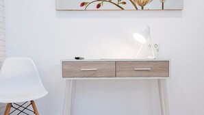 Un bureau moderne doté de deux tiroirs, une chaise blanche et une lampe de bureau.