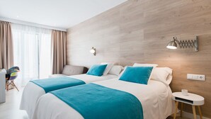 Une chambre d’hôtel moderne, équipée de deux lits, d’une petite table de chevet, d’une chaise et d’une grande fenêtre avec des rideaux.