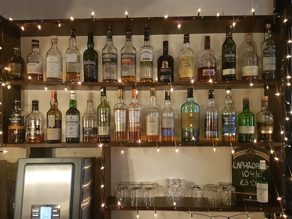 Eine Bar mit Regalen voller Spirituosenflaschen und Gläsern.
