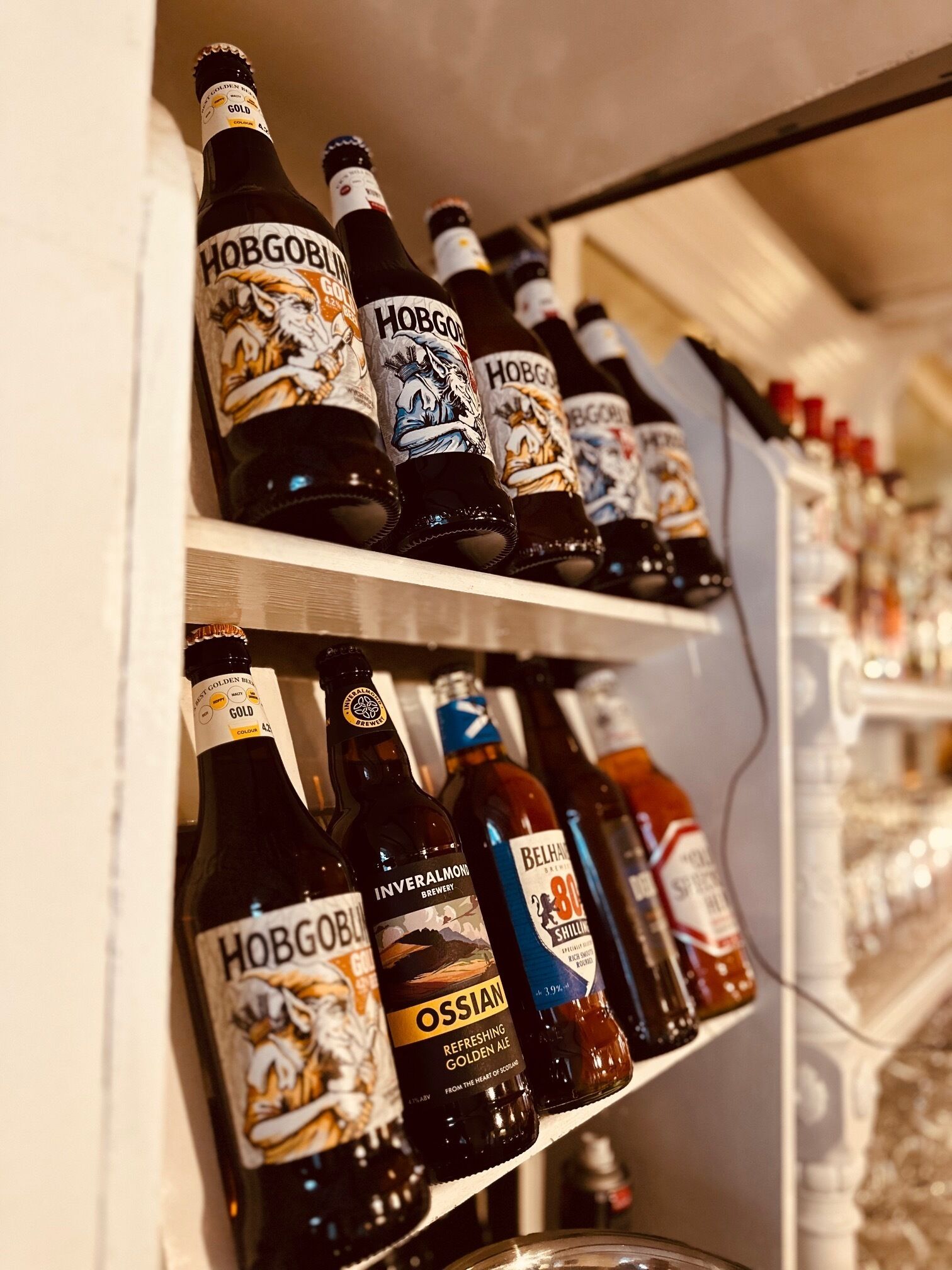 Shelves stocked with various bottles of alcoholic beverages, including brands like Hobgoblin and Inveralmond.