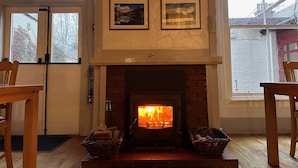 A cozy room with a fireplace, wooden furniture, and framed pictures on the wall. - Balmoral Hotel (Moffat)