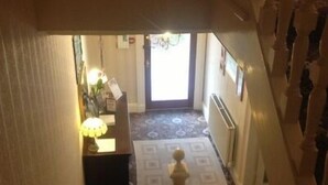 Una escalera con un suelo estampado que conduce a una puerta con una lámpara sobre ella.