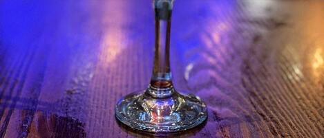 A cocktail in a martini glass with a lime garnish on a wooden table.