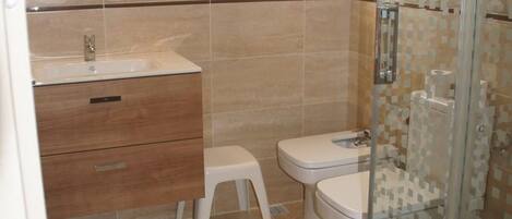A bathroom with a sink, toilet, and shower.