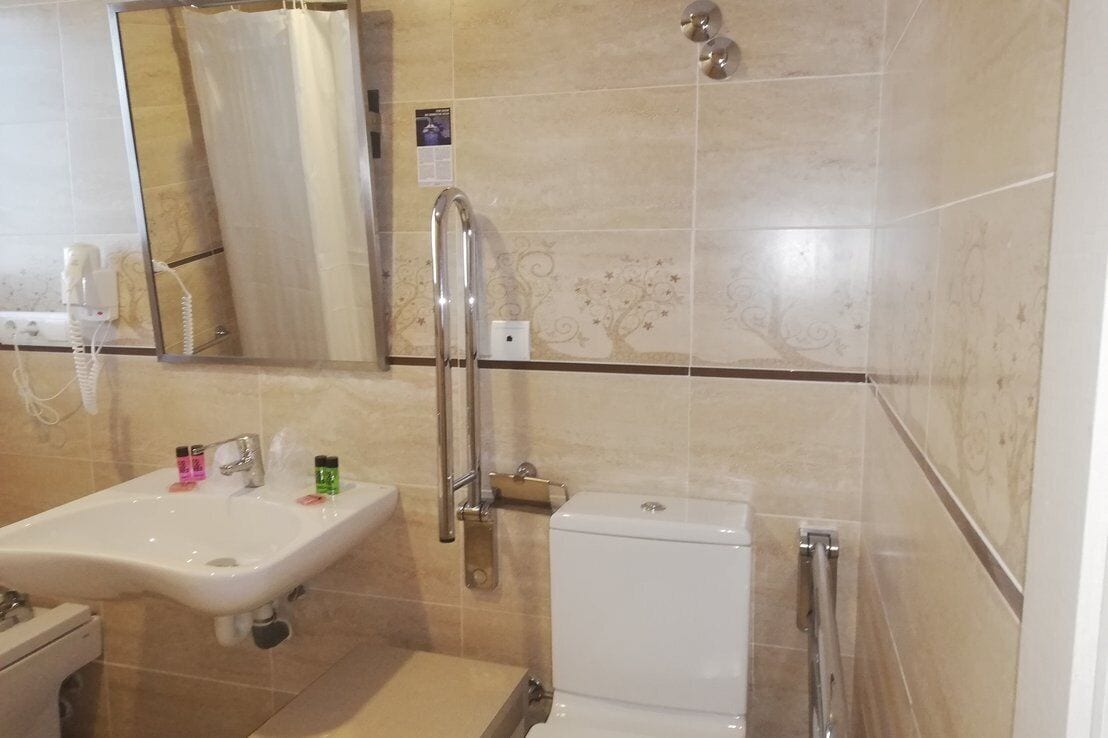 A bathroom with a sink, toilet, and shower area.
