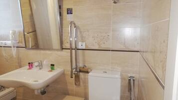 A bathroom with a sink, toilet, and shower area.