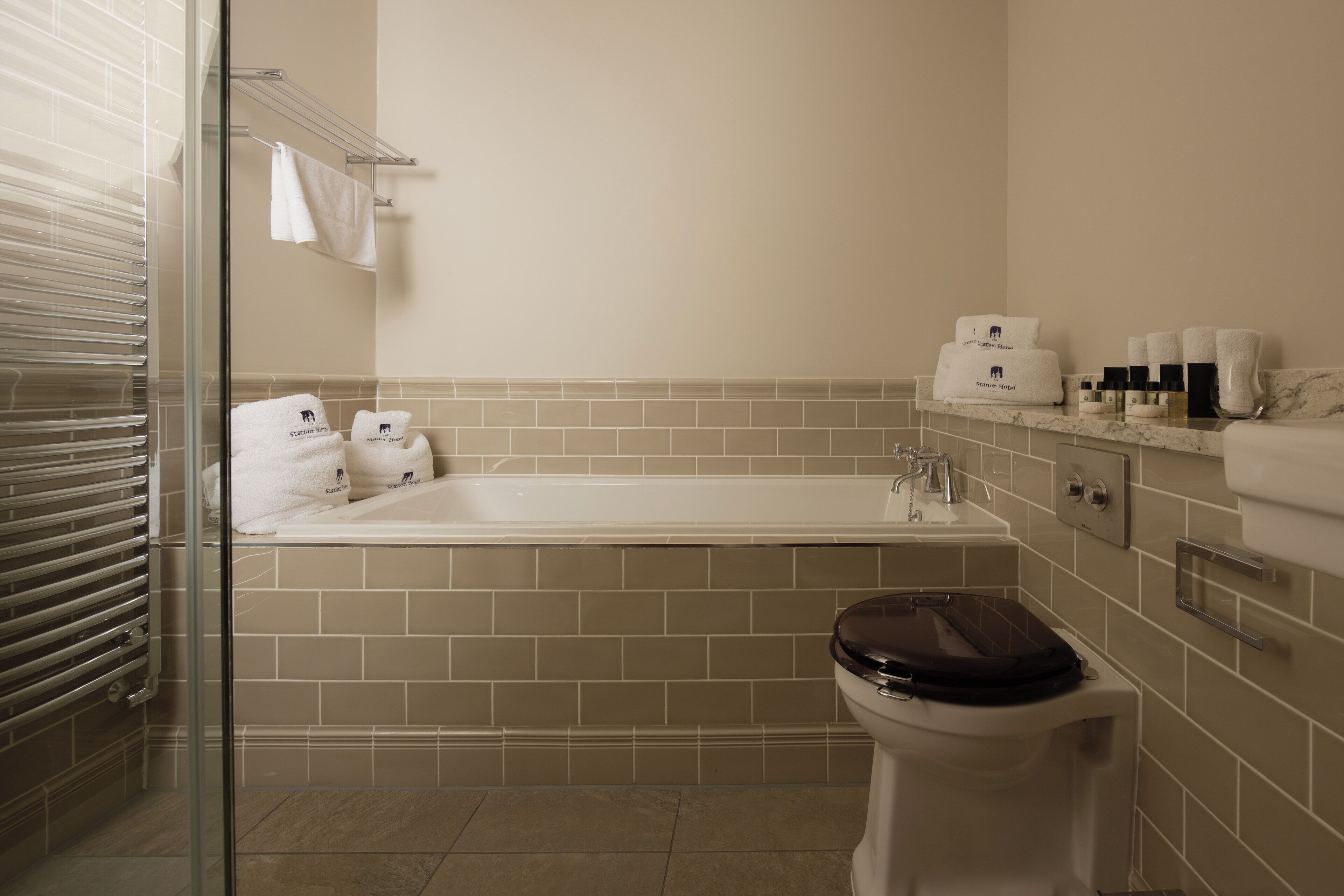 A bathroom with a bathtub, toilet, and a glass shower enclosure.