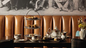 A table set for tea service with a tiered tray of pastries, teacups, and a floral pitcher. - The Station Hotel (Aberlour)