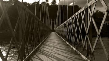 A suspension bridge with a metal framework and a paved walkway.