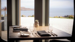 A table set for dining with a view of the sea and distant land. - The Flodigarry Hotel in the Skye  (Staffin)
