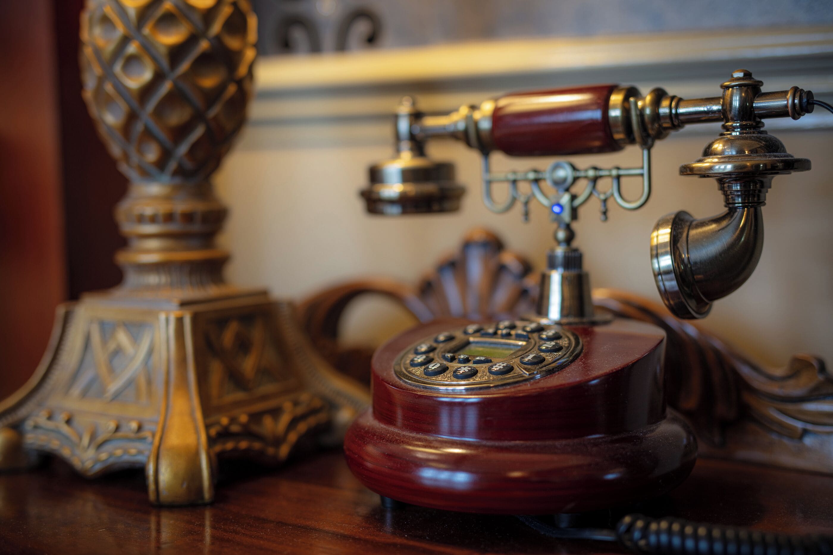 A vintage rotary telephone on a wooden table.