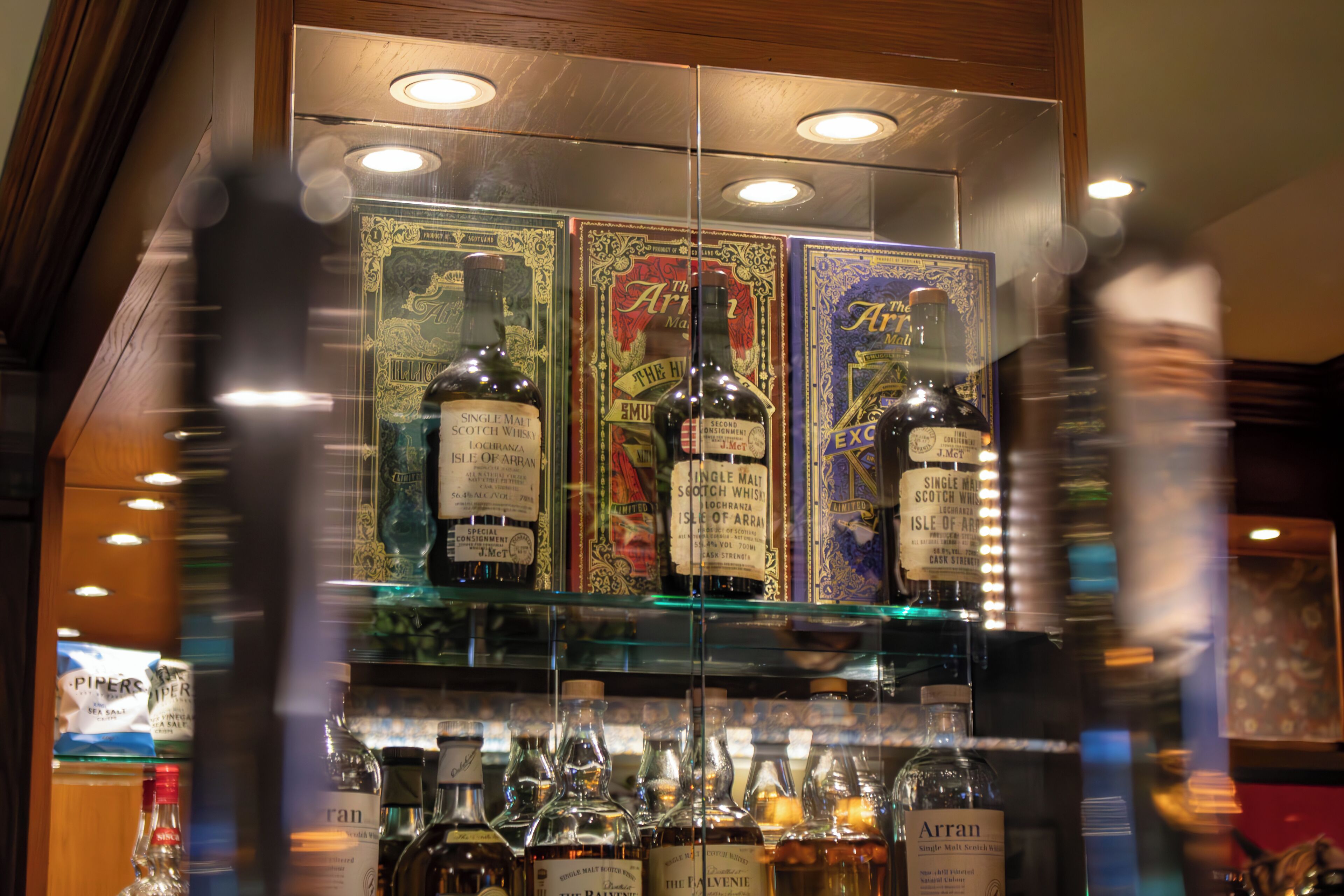A bar area with shelves of whisky bottles and glasses.