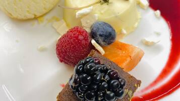 A dessert plate with various fruits and a scoop of ice cream.