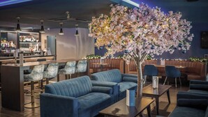 A bar area with seating, a large artificial tree, and a bar counter. - The Kinmel & Kinspa (Abergele)