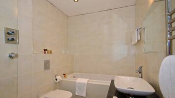 A modern bathroom with a toilet, bathtub, and sink.