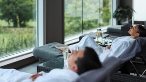 A room with a large window, a bed, a small table with a glass of water, and a plant. - The Kinmel & Kinspa (Abergele)