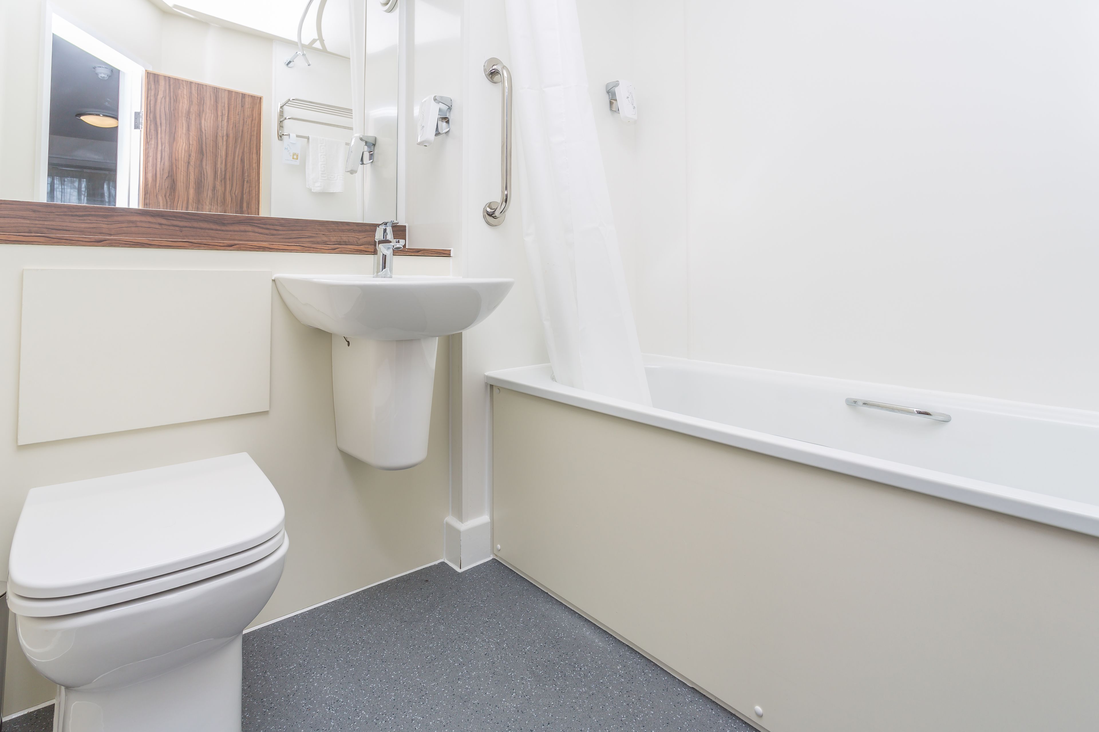Un baño moderno con inodoro, lavamanos y bañera.