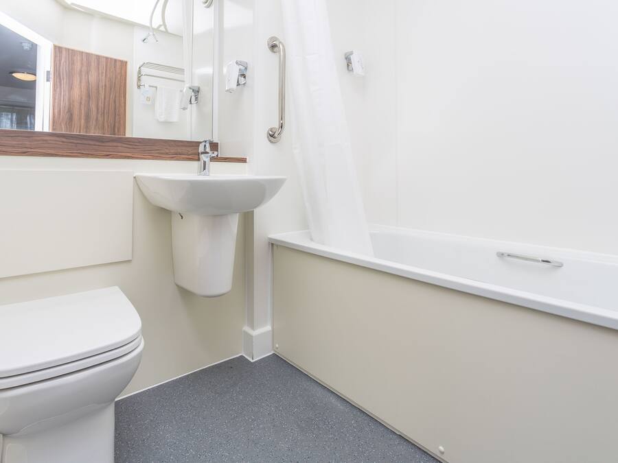 Un baño moderno con inodoro, lavamanos y bañera.