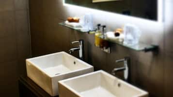 Een badkamer met twee wasbakken, een spiegel en een plank met toiletartikelen.
