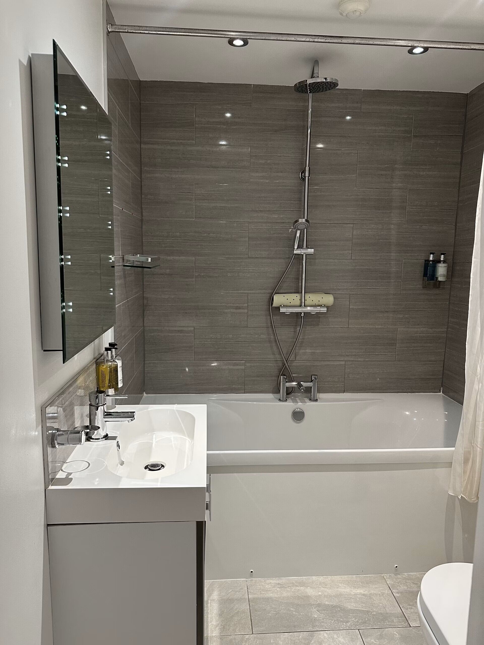 A modern bathroom with a bathtub, a sink, and a shower.