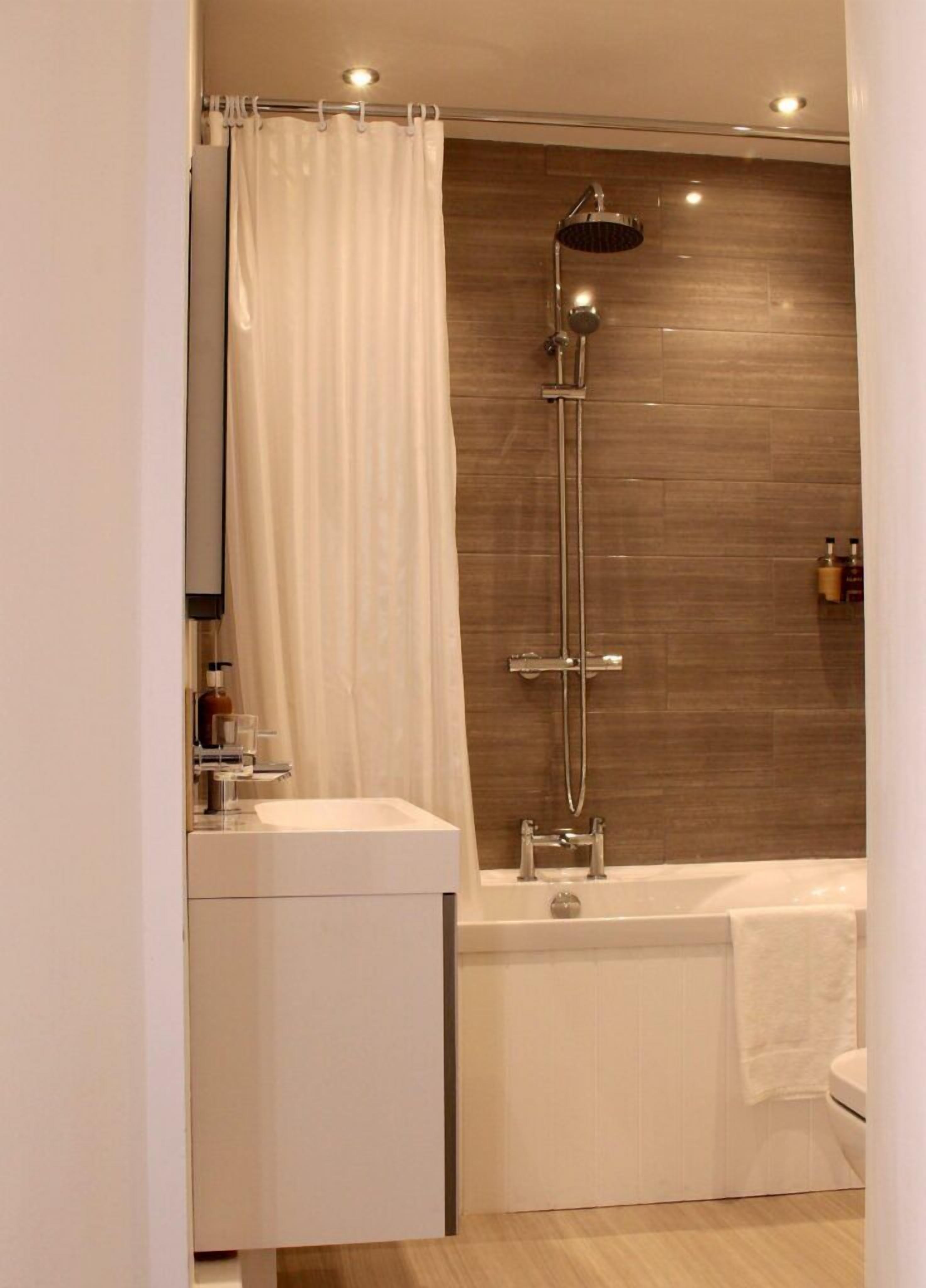 A modern bathroom with a shower, a bathtub, and a vanity.