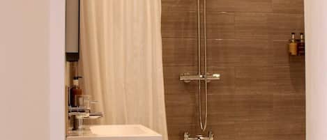 A modern bathroom with a shower, a bathtub, and a vanity.